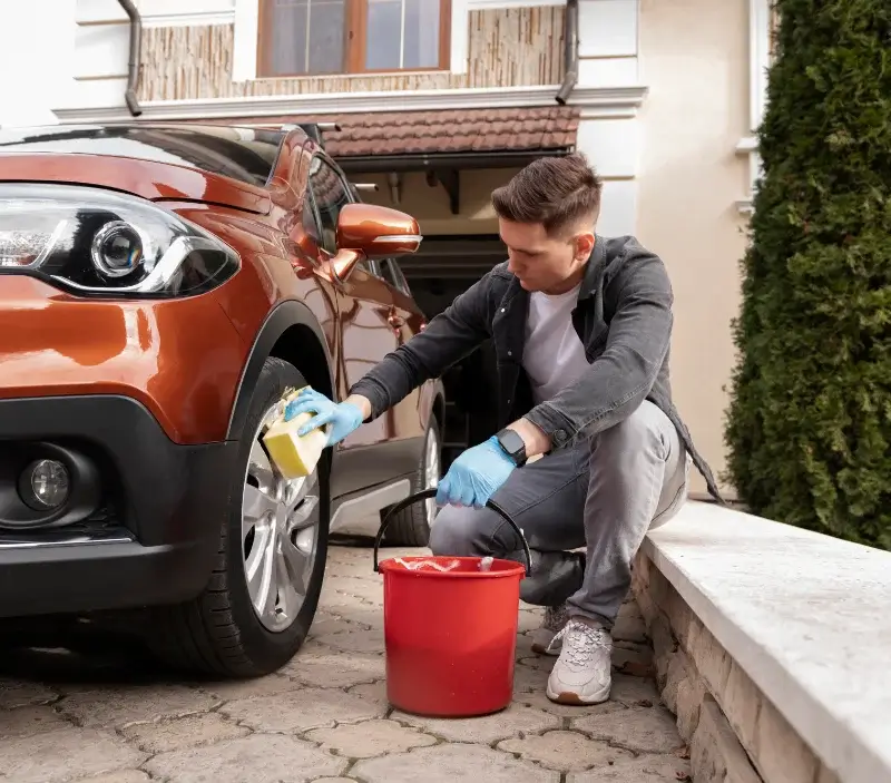 Lavage auto à domicile Dommary-Baroncourt : professionnel intervenant sur un véhicule
